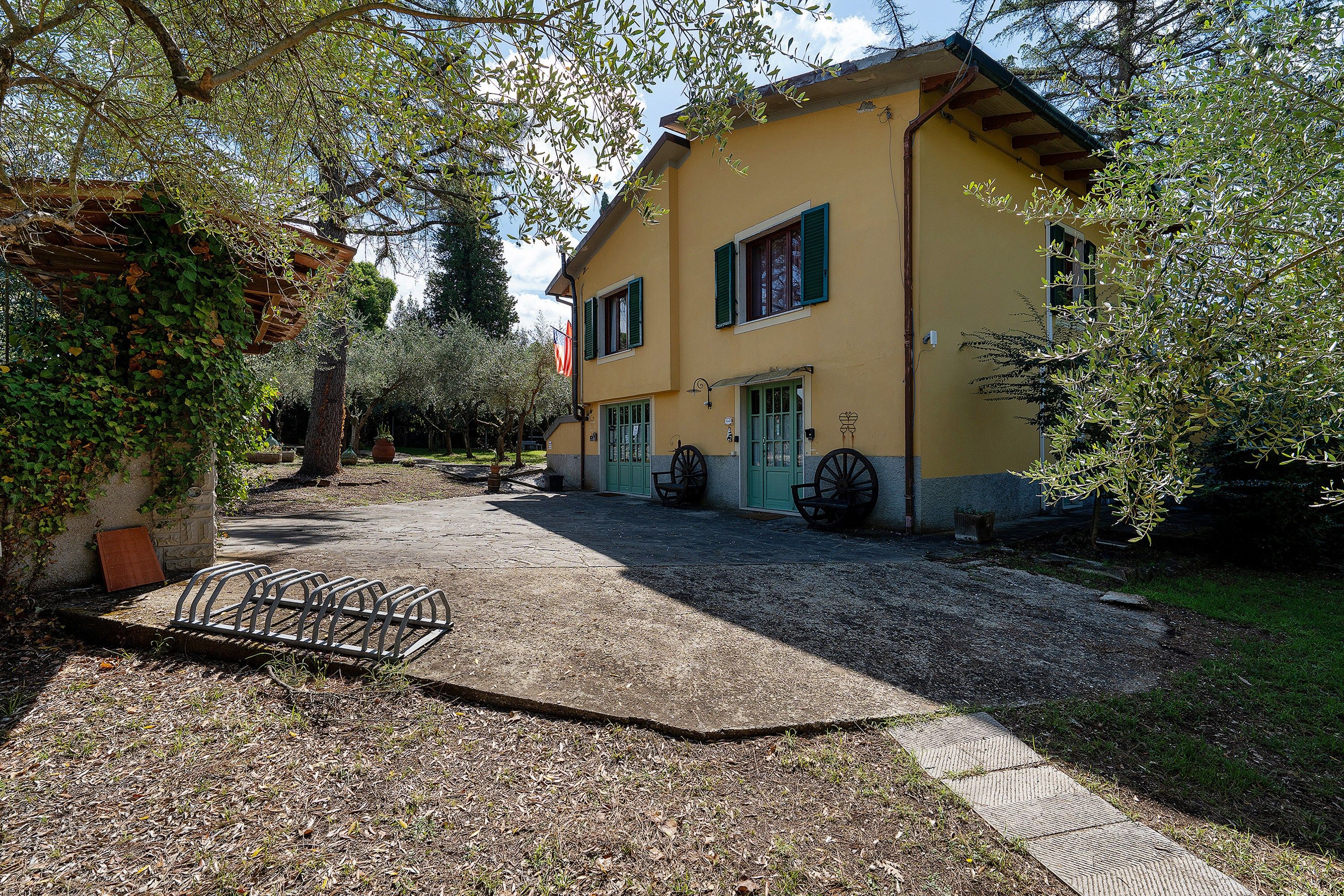 A two-story building with a gravel driveway and a metal bike rack.