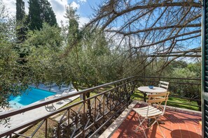 A balcony with a pool, outdoor seating, and a view of trees and sky. - Room 'Acqua' with Shared Pool, Communal Garden and Wi-Fi (Le Vedute)