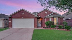 A two-story brick house with a garage, a front door, and a small front yard with landscaping. - 4BR Game Room + Firepit Sleeps 9 Near Eats (Houston)