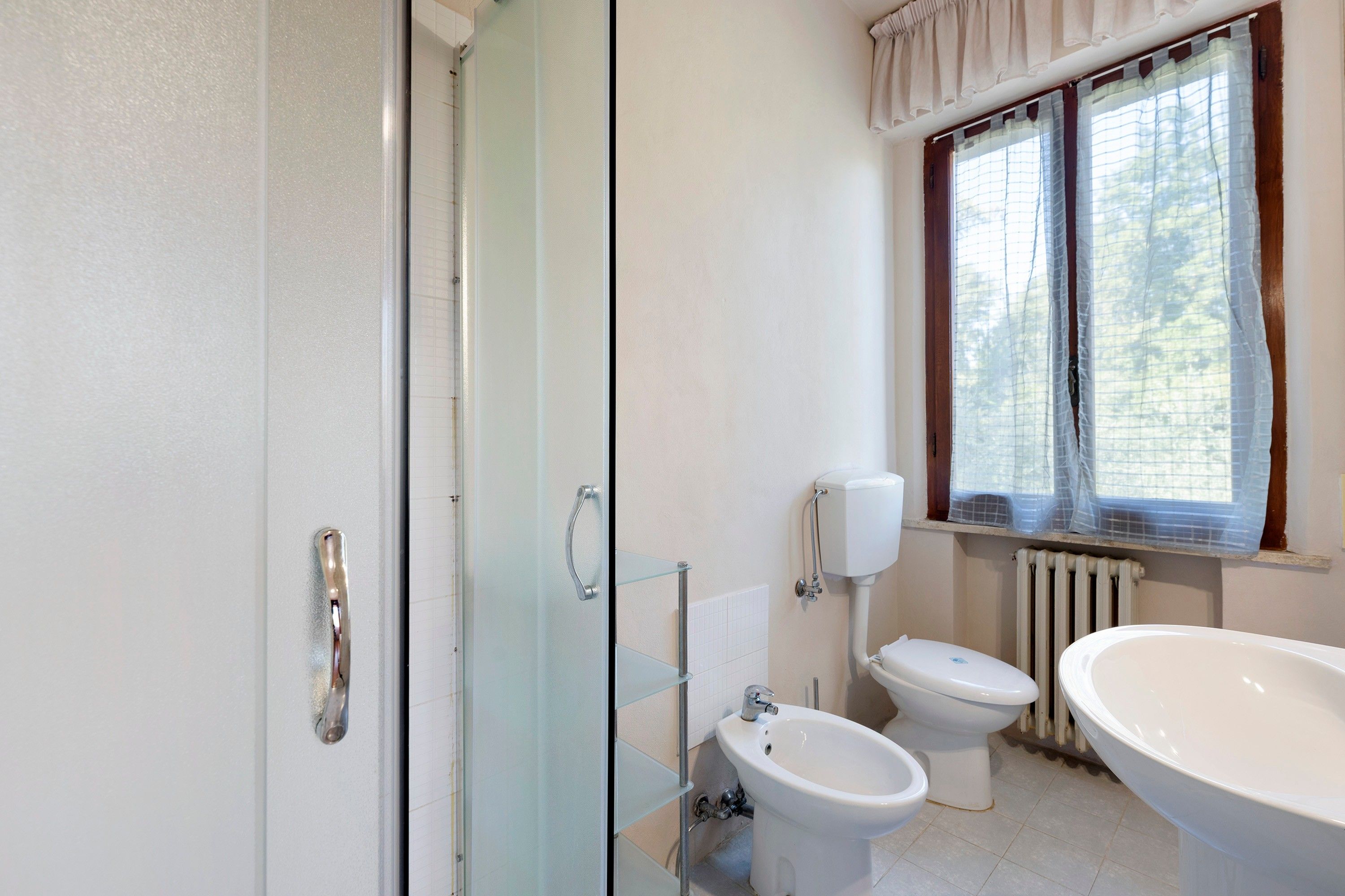 Un bagno con una cabina doccia in vetro, un bidet, un water e una vasca da bagno spaziosa.