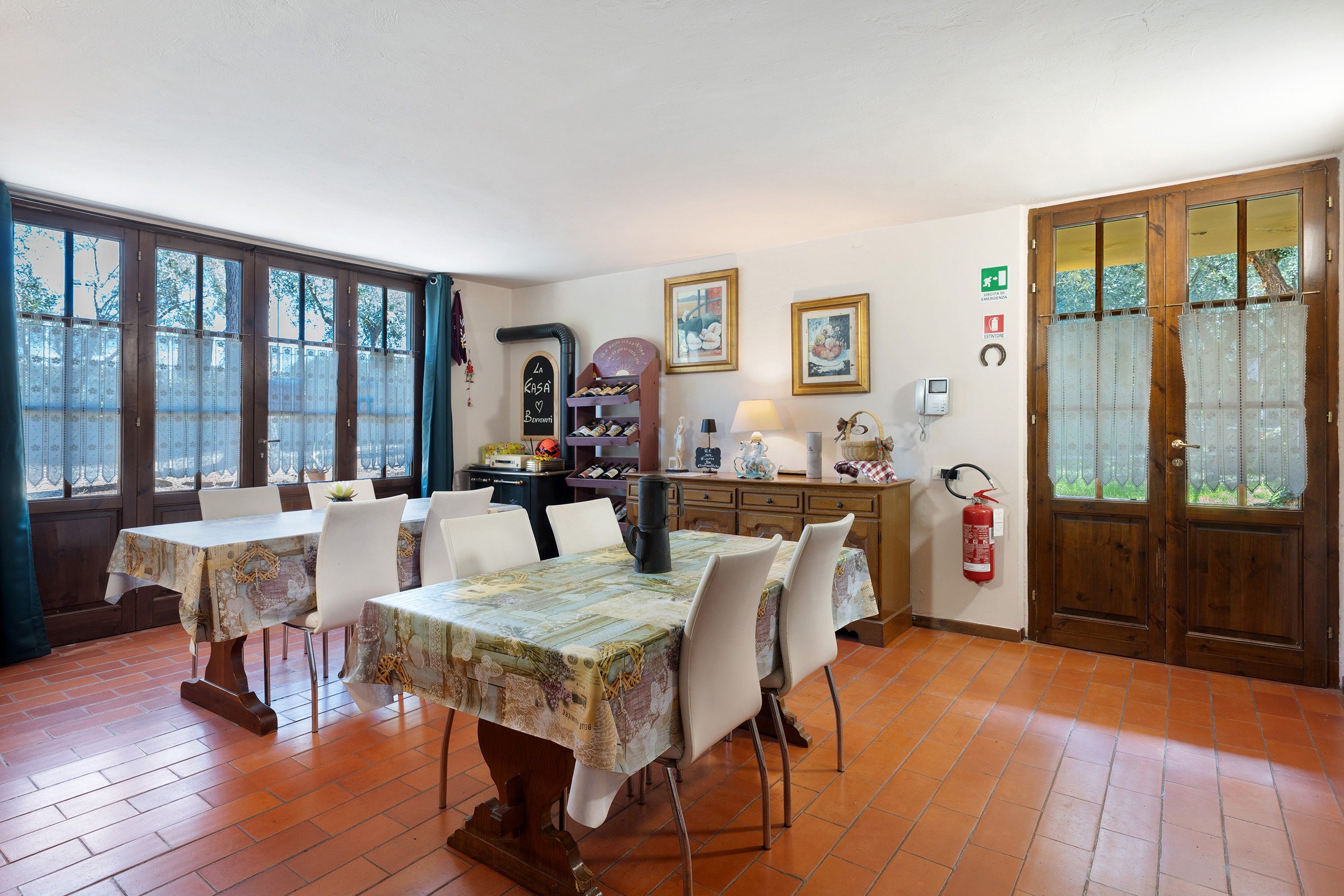 Un comedor con una mesa dispuesta para cuatro personas, un armario de madera y un extintor en la pared.