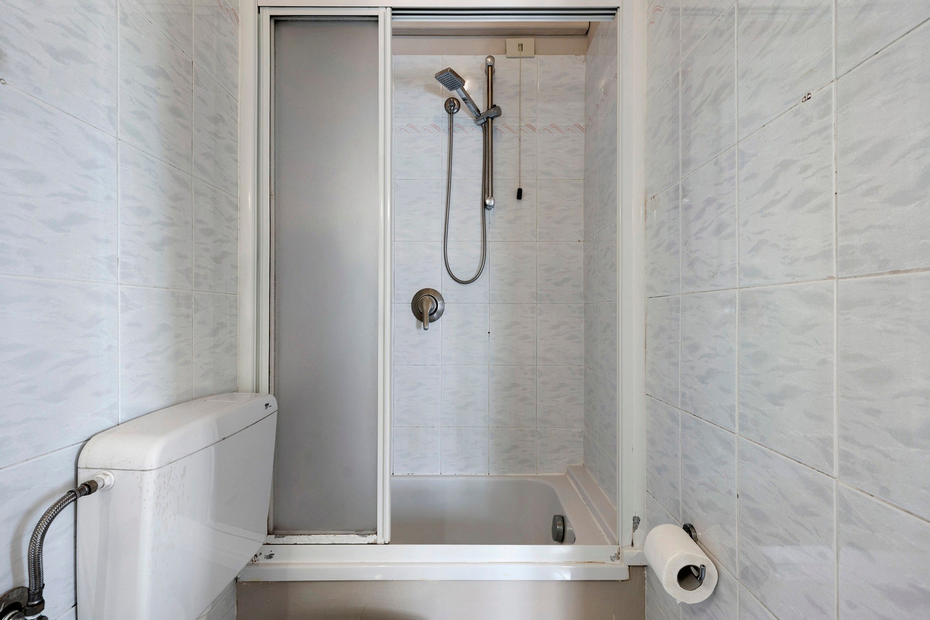 Un piccolo bagno chiuso con un water e un portasciugamani.