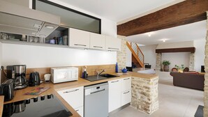 A modern kitchen with a dishwasher, coffee maker, and a microwave.