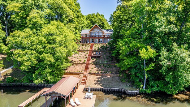 A lakeside lodge with a wooden dock, a covered seating area, and a house with a sloped roof. - The Lake Escape, Sleeps 8, Big Deep Water, Kayaks, Lily Pad + MORE! (Sparta)