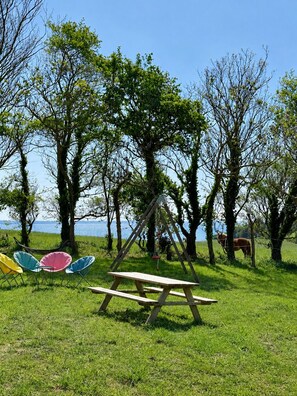 Ein Picknickplatz mit Schaukel, Stühlen und Tisch.