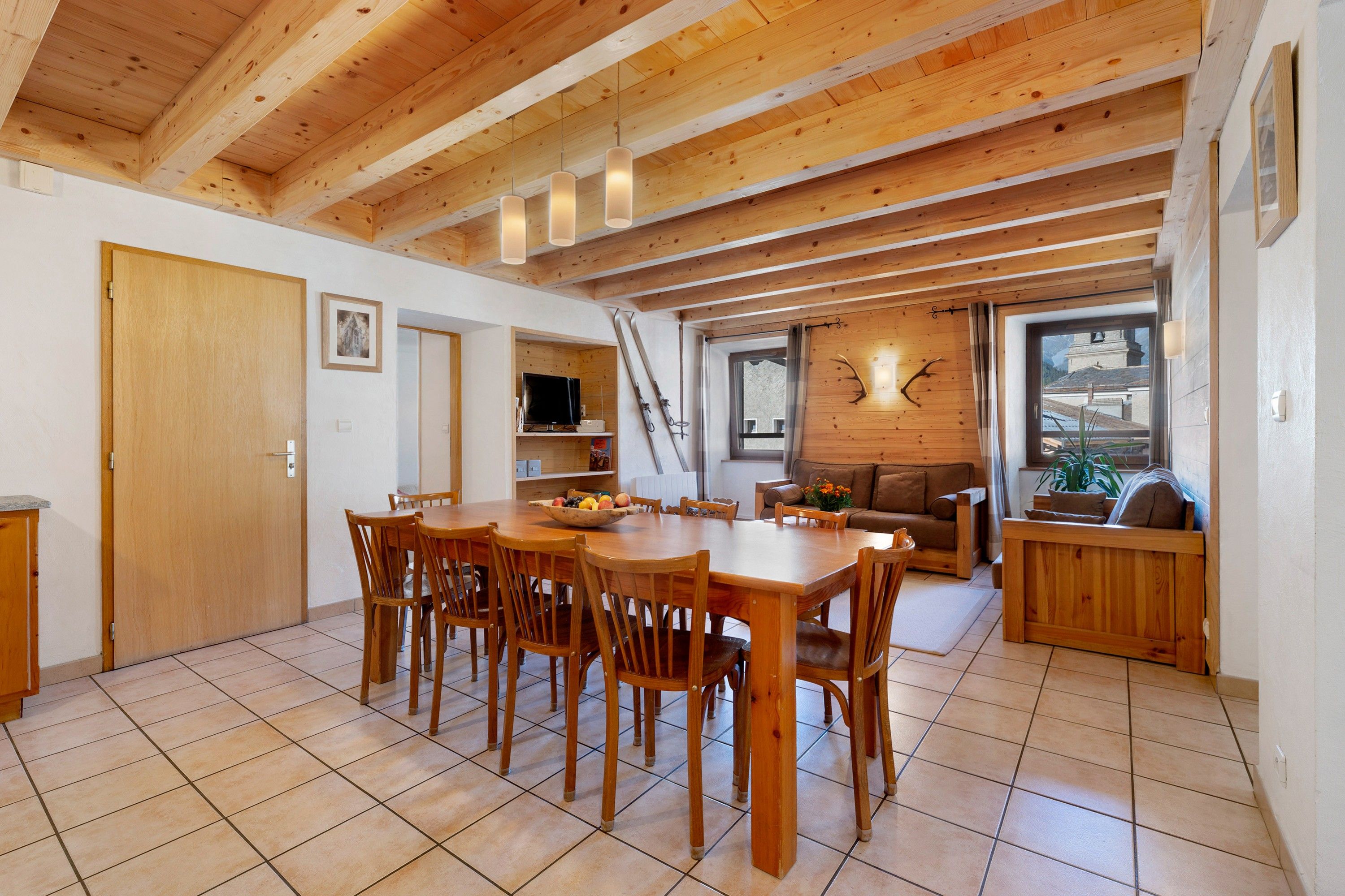 Un interior de madera con una mesa de comedor y sillas, un sofá y una chimenea.