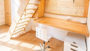 A loft-style bedroom with a wooden staircase, a desk, and a white dresser. - T3 rénové avec charme, 2 chambres cœur Tours (Tours)