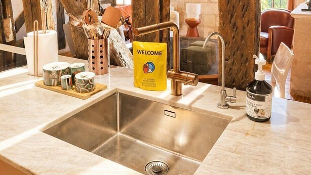 A kitchen with exposed wooden beams, a stainless steel sink, and a 'WELCOME' sign. - T3 rénové avec charme, 2 chambres cœur Tours (Tours)