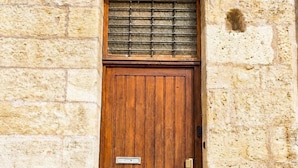 A wooden door with a metal number plate, a small window with a grid pattern, and a metal doorbell. - T3 rénové avec charme, 2 chambres cœur Tours (Tours)