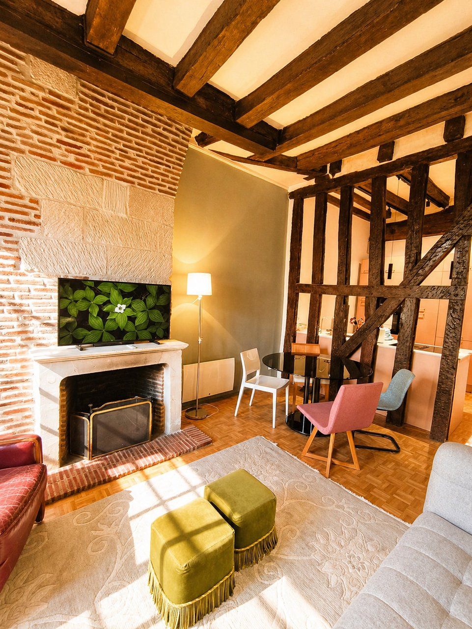 Una sala de estar acogedora con chimenea, televisor y comedor con sillas.