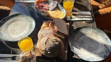 Een ontbijttafel met borden, brood, eieren en sap.