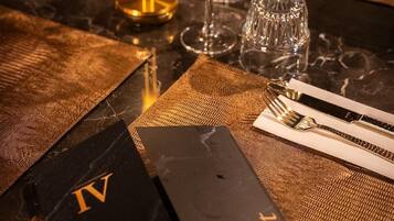 A table set with wine glasses, a candle, and a menu.