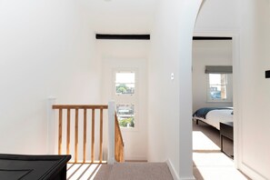 Un dormitorio con cama, ventana y vistas al exterior.
