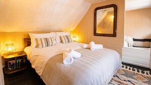 Une chambre à coucher avec un grand lit, des lampes de chevet, un miroir et un tapis à motifs.