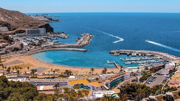 Une ville côtière dotée d’un port de plaisance, d’une plage et de bâtiments.