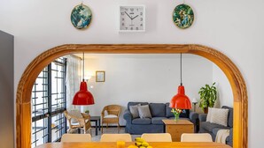 A dining area with a wooden table, chairs, a fruit bowl, and a clock on the wall. - Paseo Suiza (Las Palmas)