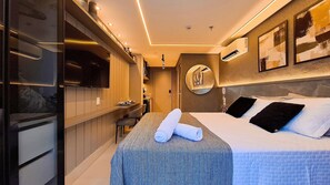 Ein modernes Hotelzimmer mit Bett, Fernseher, Schreibtisch und Spiegel.