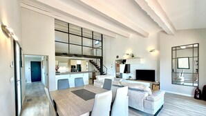 Eine moderne Wohnung mit Essbereich, Küche, Wohnzimmer und einer Treppe.