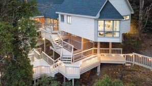 Ein zweistöckiges Haus mit Balkon, Treppe und Terrasse.