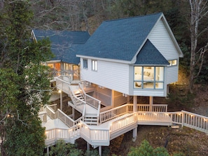Ein zweistöckiges Haus mit Balkon, Treppe und Terrasse.