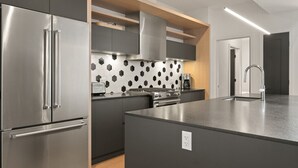 Una cocina moderna con una isla integrada, electrodomésticos de acero inoxidable y un salpicadero hexagonal.