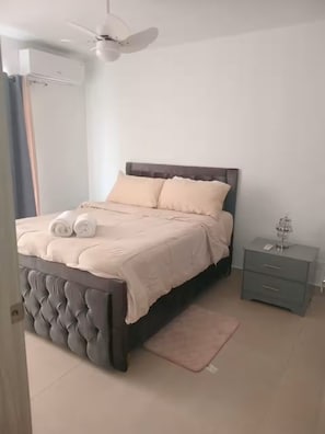 A bedroom with a bed, bedside table, and a ceiling fan. - Cozy Stylish 1-Bdrm Near Bavaro Beach & More! (Punta Cana)