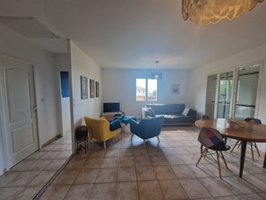 A living room with a sofa, chairs, a TV, and a dining table. - Quiet house with pool in Cers, 10 minutes from the beach (Cers)