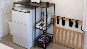 A kitchenette with a refrigerator, a toaster, a coffee maker, and a TV mounted on the wall. - Downtown Ogunquit!  Steps to the Beach, Dining & Shops! Park & Walk Everywhere! (Ogunquit)