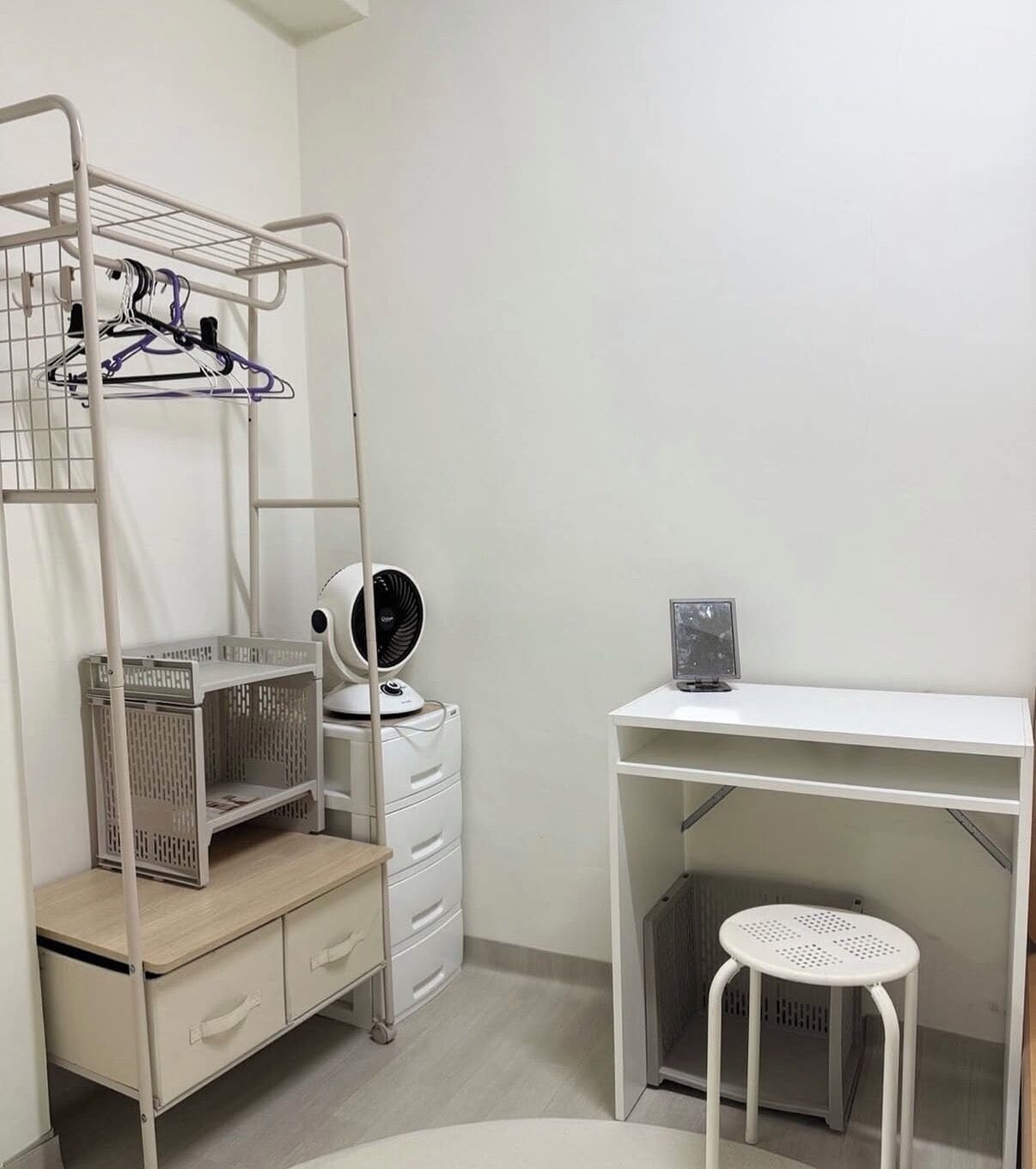 A room with a bunk bed, a desk, a chair, and a washing machine.