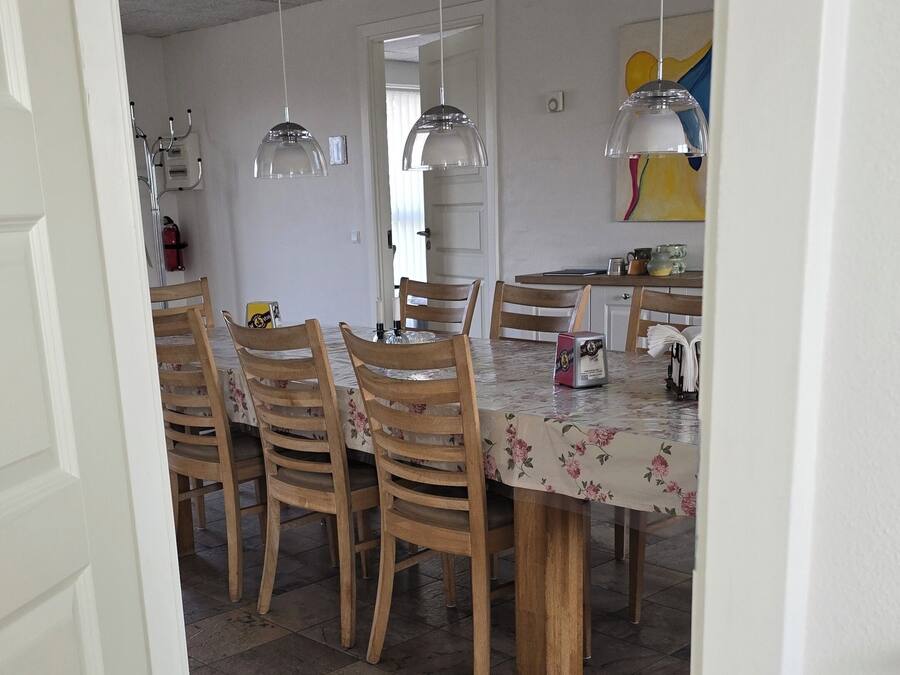 A dining area with a table, chairs, and pendant lights.