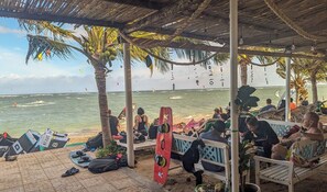Eine Strandlounge mit Sitzgelegenheiten, Sonnenschirmen und Strandausrüstung.