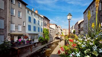 Un canal bordé de bâtiments des deux côtés, un pont et un lampadaire.