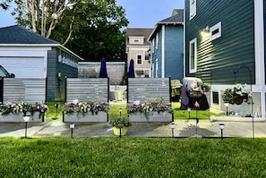 A residential area with houses, a lawn, and flower planters.