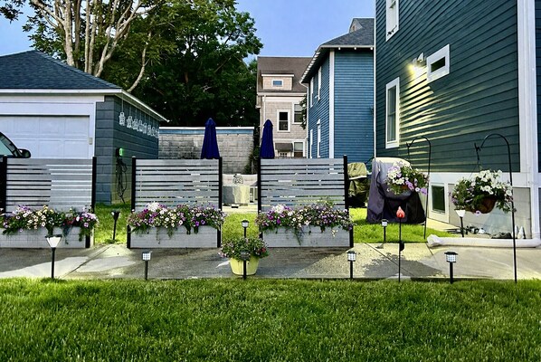 A residential area with houses, a lawn, and flower planters.