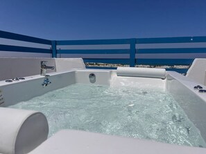 Un bain à remous avec de l’eau claire, un robinet et un panneau de commande.