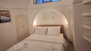Un dormitorio con cama, ventana, cuadro y puerta.