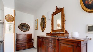 A room with a wooden dresser, a bed, and a large mirror. There are framed pictures on the walls. - Apartment 200 Meters From the Beach (Castelsardo)