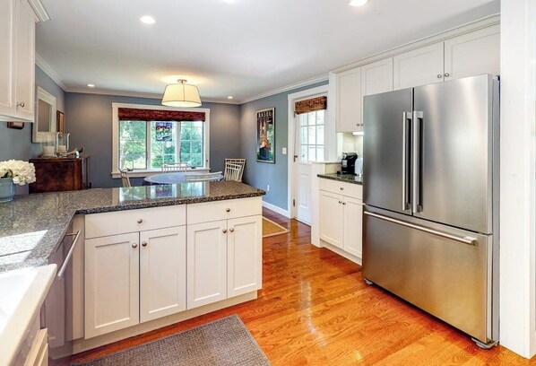 A kitchen with white cabinets, a stainless steel refrigerator, and a granite countertop. - 6 Central: Lovely home within walking distance of the bay & dining (Camden)
