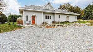 Ein Bungalow mit Kiesweg, Haustür und kleiner Veranda.