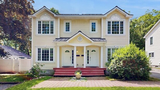 A two-story house with a front porch, a garage, and a well-maintained lawn. - Perfect Cottage Near Downtown & Glen Mary Park w/ Full Kitchen, Free WiFi, More (Bar Harbor)