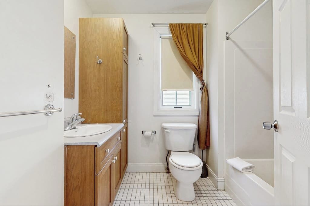 Un baño pequeño con inodoro, lavabo y ducha.