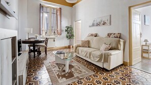 Una sala de estar con sofá, mesa de centro y comedor con sillas y mesa.