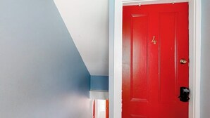 En rødmalede dør med nummeret '4' og en keypad-lås, en blå væg og et hvidt loft.