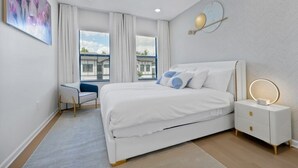 Un dormitorio moderno con cama, mesita de noche y escritorio.