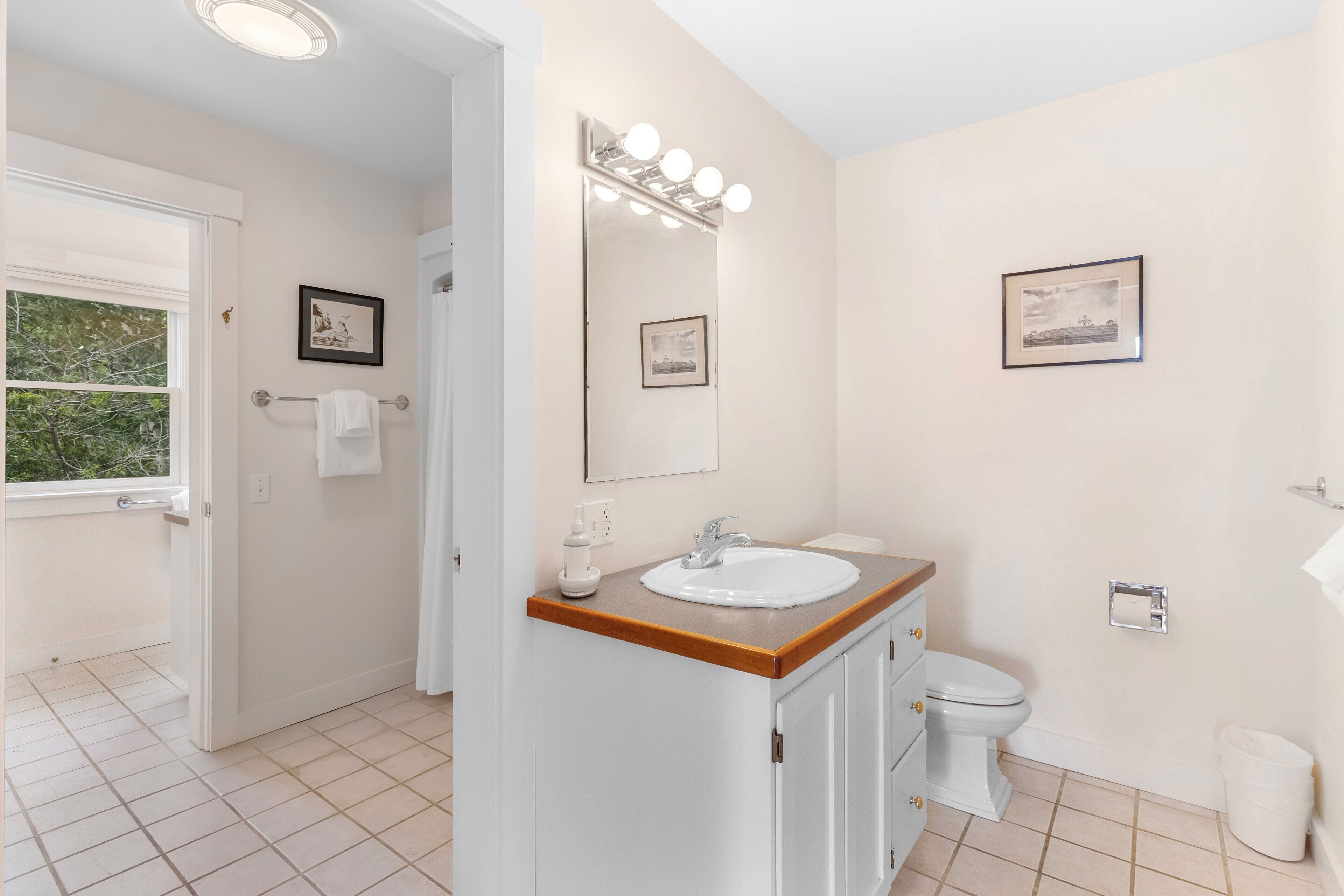 Un baño con lavamanos, espejo e inodoro.