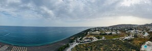 Eine Küstenstadt mit Strand, Häusern und einer hügeligen Landschaft.