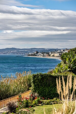 Eine Küstenlandschaft mit Blick auf das Meer, einen Strand und eine Stadt in der Ferne.