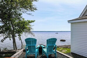Two chairs facing a body of water with a tree and a building in the background. - Cozy Studio with Lofted Sleeping Space and Great Water View (Surry)