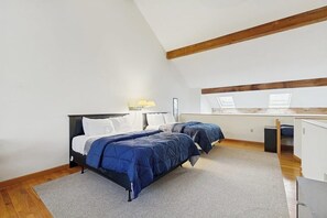 A bedroom with a bed, two bedside tables, a desk, and a chair. - Townhome w/ Bonus Loft, High-Speed WiFi, Partial AC & Full Kitchen (Bar Harbor)