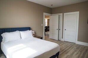 Een slaapkamer met een bed, nachtkastje en garderobe.